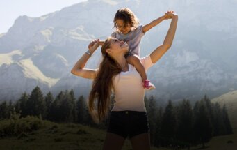 Een au pair met een kind in de bergen